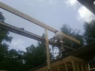 Carpenter setting a ridge beam over a new addition frame — Ice Dam Removal by Roofing Brothers in Temperance