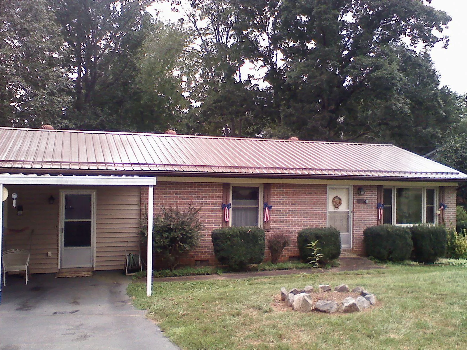 Bronze metal roof and carport on a brick ranch home — Roof Repair work by our crew in Temperance